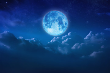 Wall Mural - Beautiful blue moon behind cloudy on sky and star at night. Outdoors at night. Full lunar shine moonlight over cloud at nighttime with copy space background for headline text and graphic design.