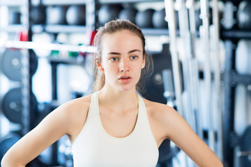 Sticker - Young woman in gym, in white tank top, resting