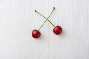 Sweet fresh cherries on white wood background