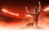 soccer player on soccer stadium celebrating a goal on red smoke background