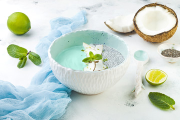 Wall Mural - Vegan blue spirulina smoothie and chia pudding bowl topped with coconut flakes and lime zest