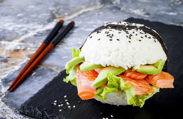 Wall Mural - Homemade asian style gluten free sushi salmon burger. Sushi-food hybrids trend. Bright blue background with copy space