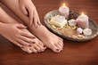 © Africa Studio - Female feet and hands with brown manicure and spa composition on wooden background