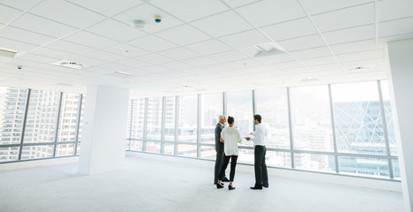 estate agent with clients inside an empty office space