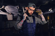 © Fxquadro - Mechanic holds angle grinder on a shoulder.