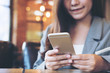 © Farknot Architect - An Asian business woman holding and using smart phone in modern cafe