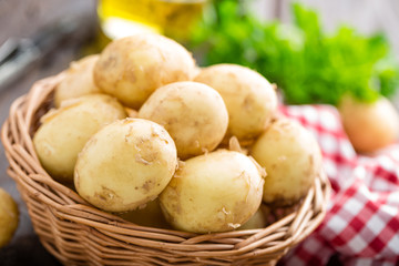 Sticker - Raw potato in basket on wooden table closeup