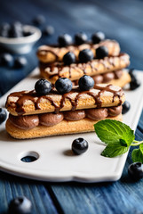 Wall Mural - Savoiardi filled with cocoa cream and topped with chocolate and blueberry