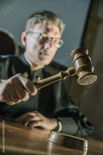 Fotografija a judge with a hammer in his hand in the court room