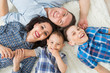 © SergeyCash - Happy family, mother, father and two sons having fun lying on the floor, upper view