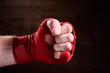 © Aleksey - Close up image of fist of a boxer with red bandage against brown background.