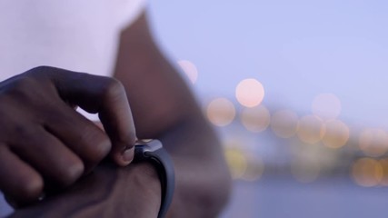 Closeup Of Man using His Smartwatch With City Lights In Background