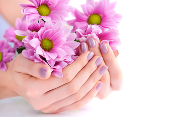 Wall Mural - Hands of a woman with pink manicure on nails and pink flowers