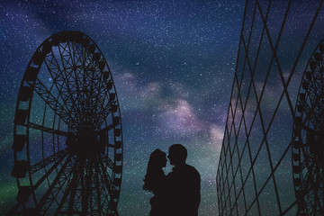 Sticker - Lovers in amusement park at night. Vector illustration with silhouette of loving couple under starry sky. Ferris wheel and glass building