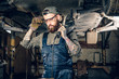 © Fxquadro - Mechanic holds angle grinder on a shoulder.