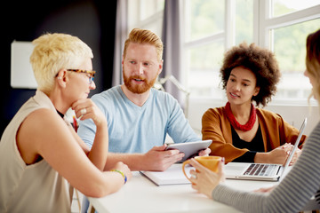 Multi-ethnic group having a meeting or presentation in modern office