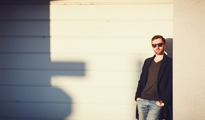 Wall Mural - Stylish handsome man is posing next to wall. Copy space