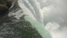 AERIAL CLOSE UP Flying Above Scenic Niagara Falls Along The Edge Of A Cliff. Whitewater Rapids Breaking And Crushing Into The Bottom Of The Waterfall. Thick Fresh Mist Rising Above The Horseshoe Falls