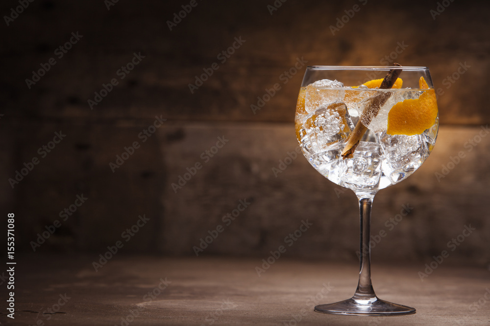 Gin and tonic cocktail on a wooden table with background - obrazy, fototapety, plakaty 