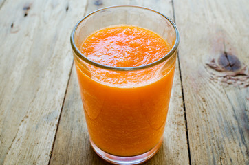 Wall Mural - Pumpkin Smoothie. Healthy blended juice on rustic wooden table. Shot on daylight