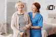 © zinkevych - Excellent private nurse helping mature lady standing