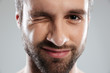 © Drobot Dean - Cropped image of a bearded mans face winking