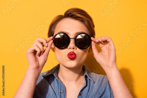 Photographie Kiss for you! Fashionable young cute girl in trendy sunglasses sends a kiss agai