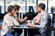 © LIGHTFIELD STUDIOS - business team on meeting discussing project with laptop in cafe, business lunch concept