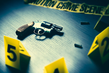 Wall Mural - dramatic lit crime scene with gun and markers on the floor