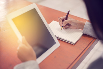 Beautiful business working woman using Ipad while working with laptop