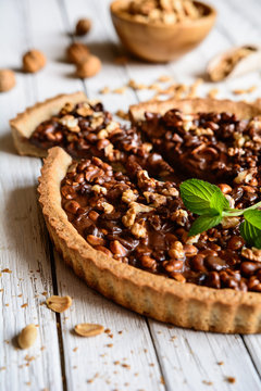 Delicious chocolate tart with walnut, peanut, dried cranberry and raisins