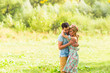 Couple embracing on the countryside. Young romantic man and woman standing and hugging each other with tenderness on nature. Young love concept.