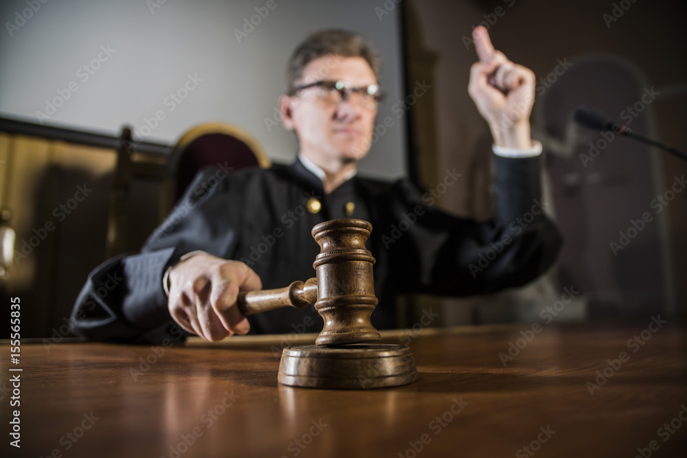 a judge with a hammer in his hand in the court room - obrazy, fototapety, plakaty 