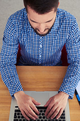 Wall Mural - Mature guy printing in laptop in bright room