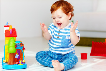 Wall Mural - happy little redhead baby playing with toy house