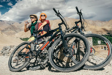 Two cyclists rest n the mountain road