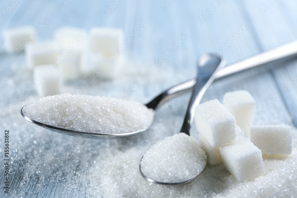 Spoons with sugar on table, closeup