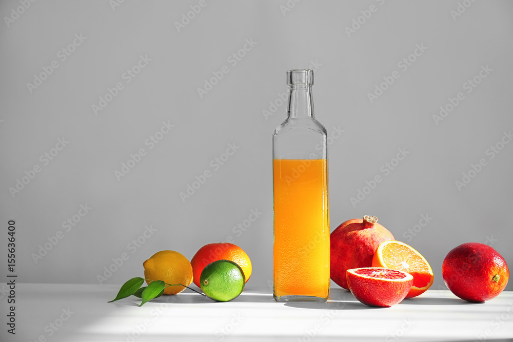 Beautiful composition with citrus fruits and juice on light background