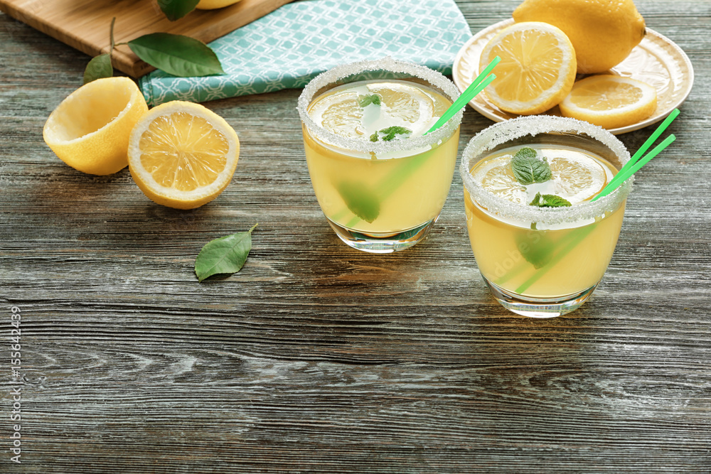 Glasses of lemon juice on wooden table