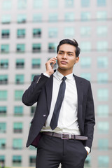 Wall Mural - Asian Business Man Calling on Phone Outside