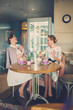 © Nejron Photo - Two elegant young ladies in a cafe