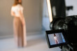 © Photodrive - Display of camera with live view model photo. Beauty blogger shooting fashion video in studio