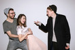 © Photodrive - Group of friends have fun together at party. Woman and two men in playful mood on white background. Casual youth communicate, laugh and smiles