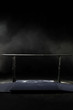 Closeup. Gymnastic parallel bars. Isolated on black background with fog, Vertical shot.