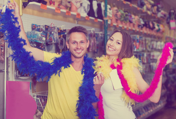 Smiling young couple measuring the colorful boa