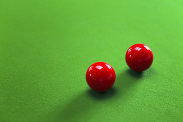 Two red snooker balls on green table