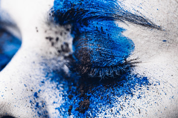 Wall Mural - close up eye of fashion model girl with colorful powder make up. Beauty woman with bright blue makeup and white skin.