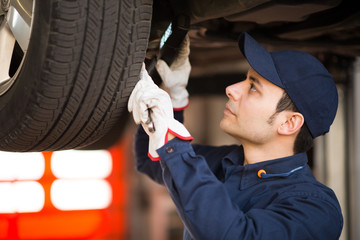 Poster - Mechanic inspecting a car