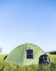 Wall Mural - The tent stands in a clearing in the woods solar panel hangs on the tent.