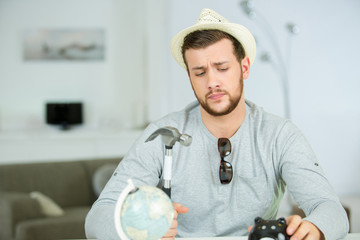 man regrettfully poised to smash open piggybank